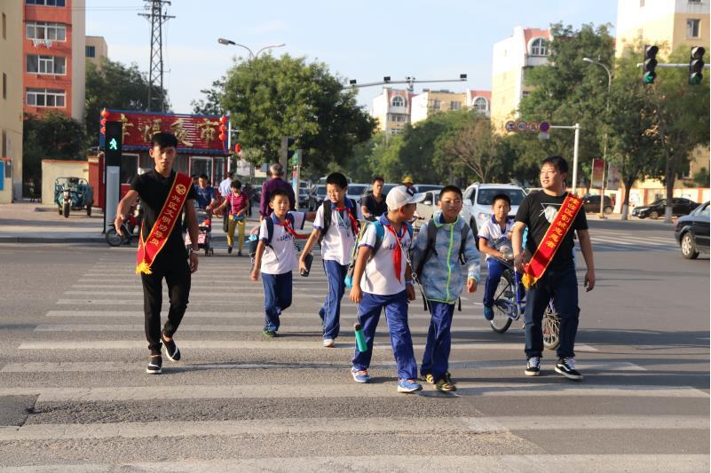 志愿者引導(dǎo)學(xué)生過馬路